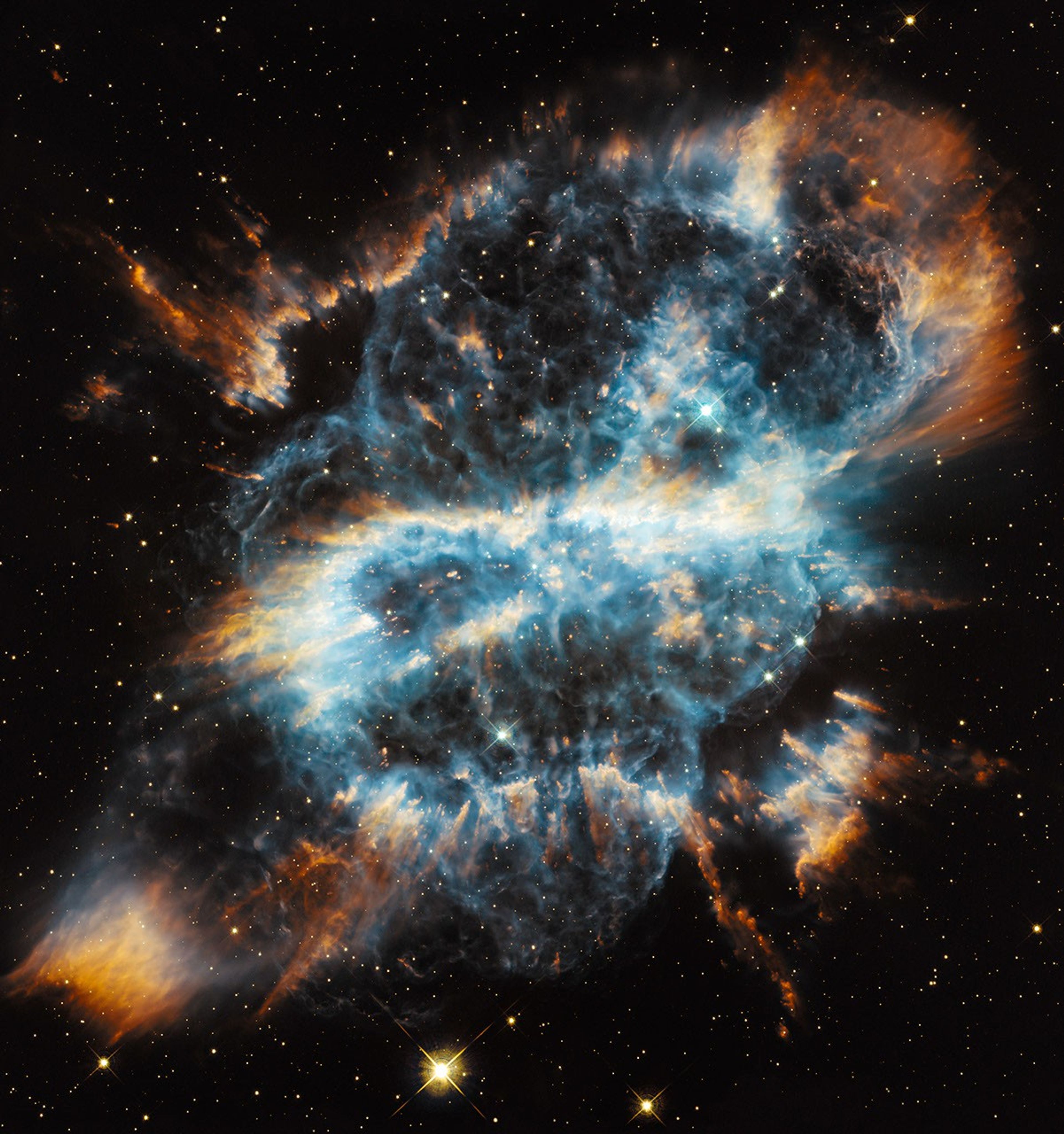 A blue cloud of gas and dust, adorned with filaments and knots of gas in red, orange, and yellow. It resembles a skull, with the thicker gas filament forming a "mask" around the "eyes".