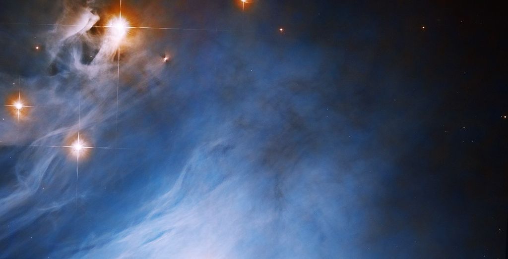 Bright blue cloud fills the scene, orange-red rings surround bright-white stars in the upper-left corner of the image.