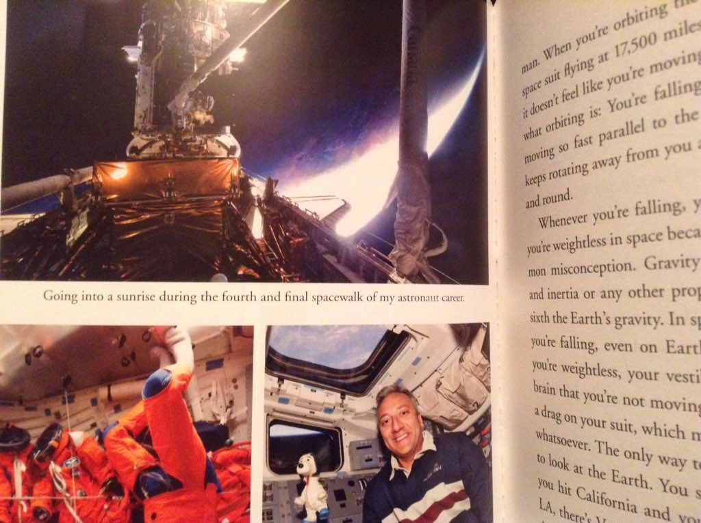 A photo from a book, primarily focusing on the page on the left, which has three pictures from Hubble servicing missions.