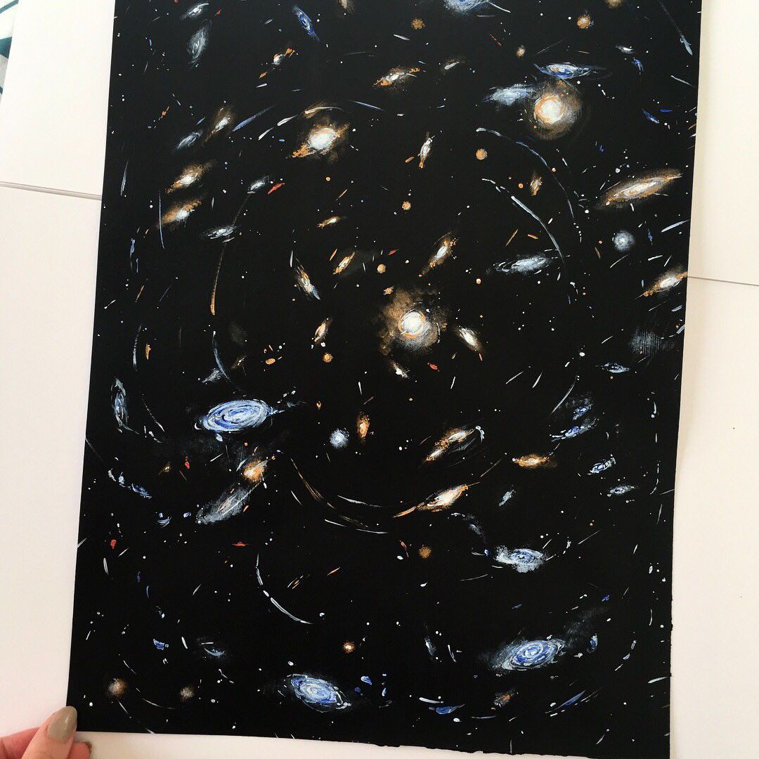 A painting of a galaxy cluster on an acrylic board. The background is black, with many galaxies of different colors and shapes painted throughout. Thin, white streaks form curved arcs to represent the effects of gravitational lensing.