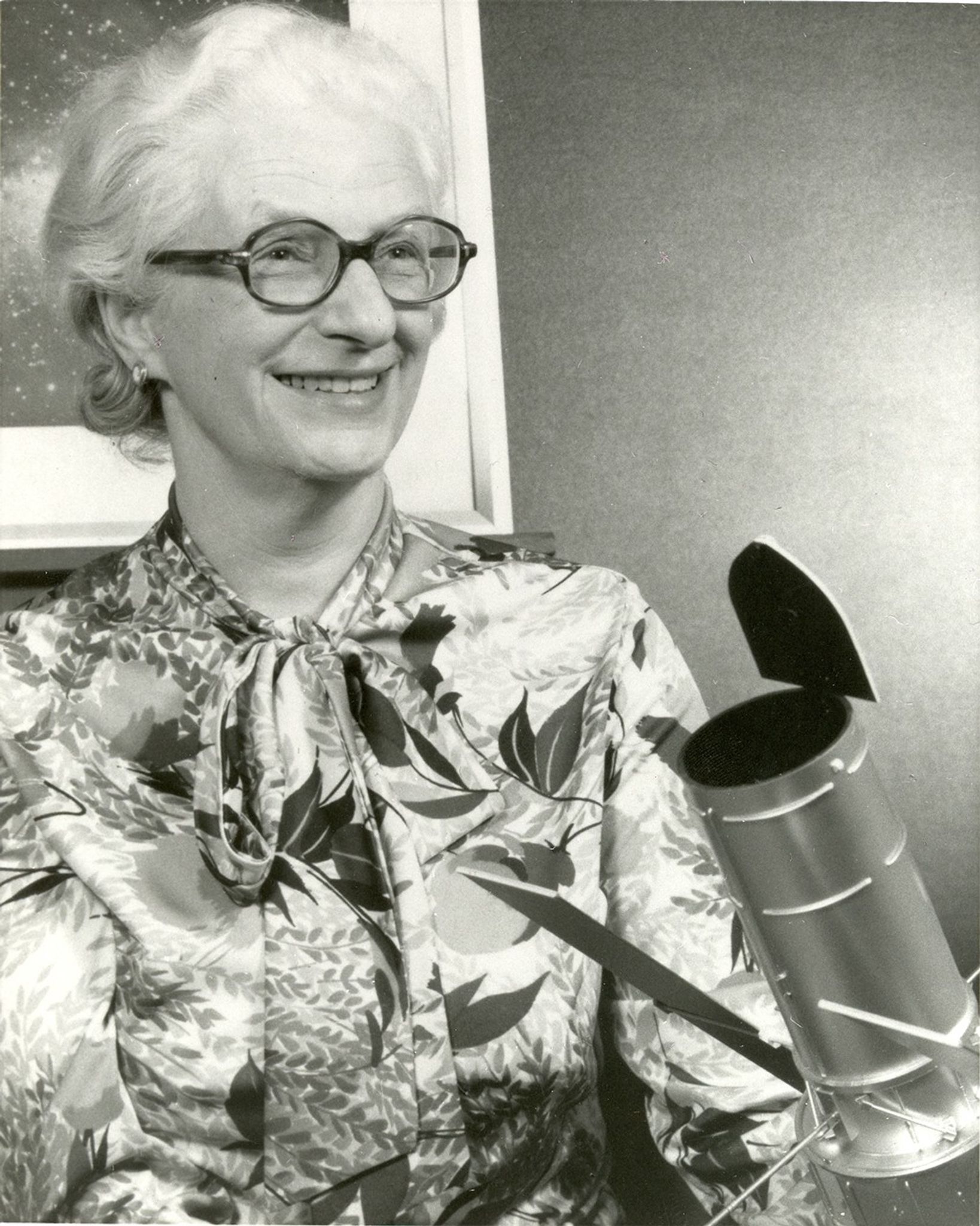 Dr. Nancy Grace Roman poses with a model of the Hubble Space Telescope.