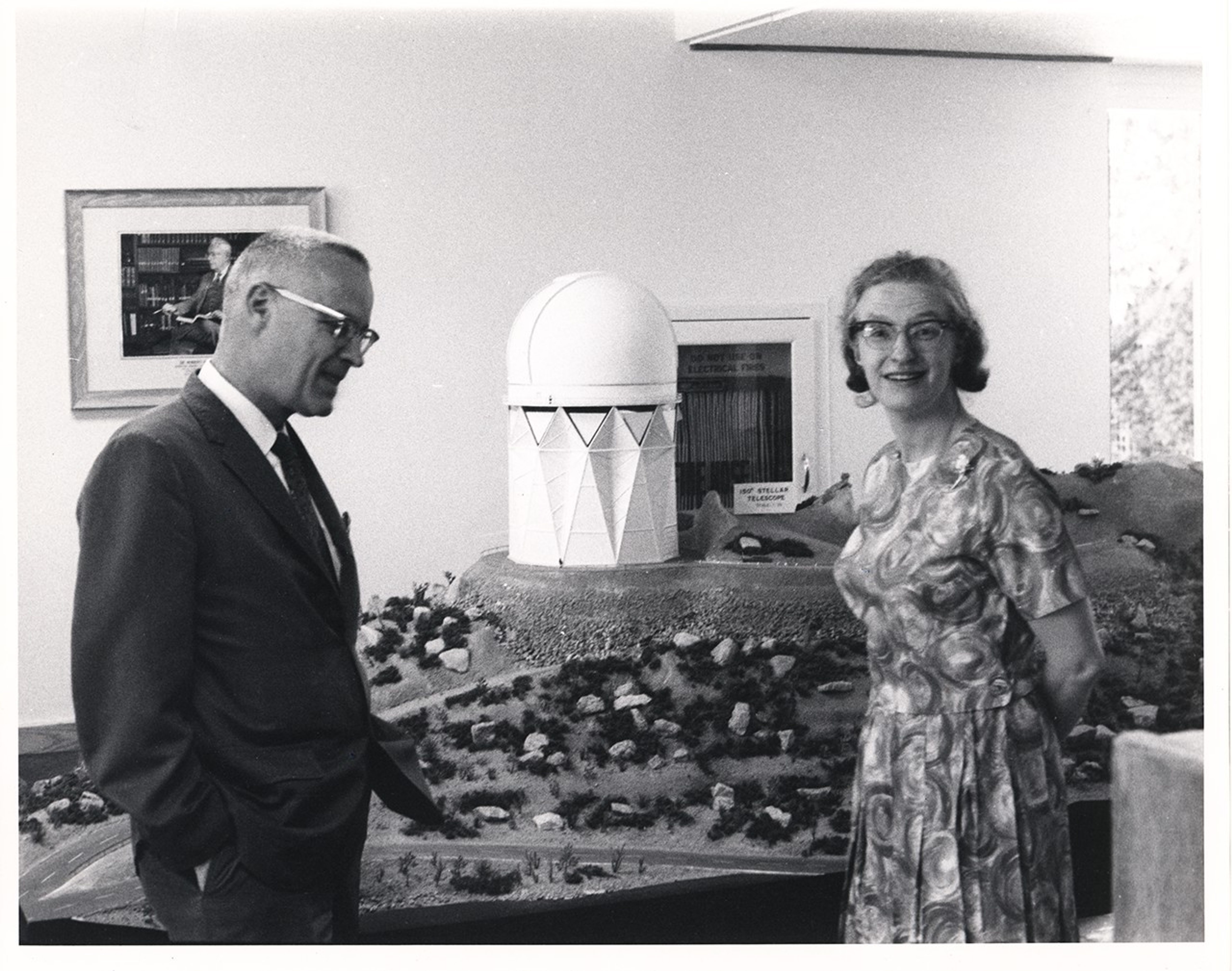 Dr. Nancy Grace Roman talks with Homer Newall in front of a model of Kitt Peak and its Mayall 4-meter telescope.