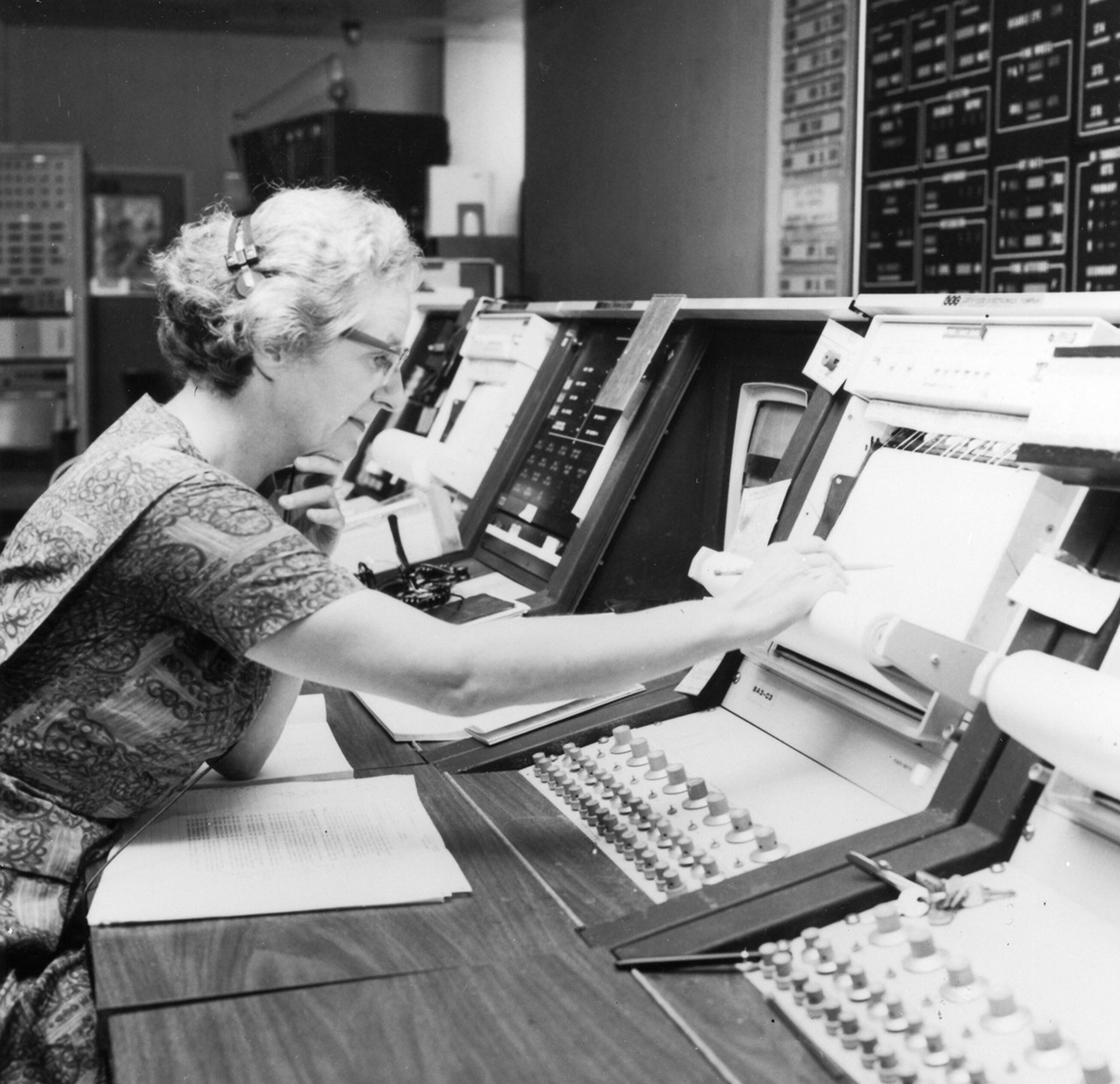 Dr. Roman sits at a telescope control console, with a book of instructions in front of her.