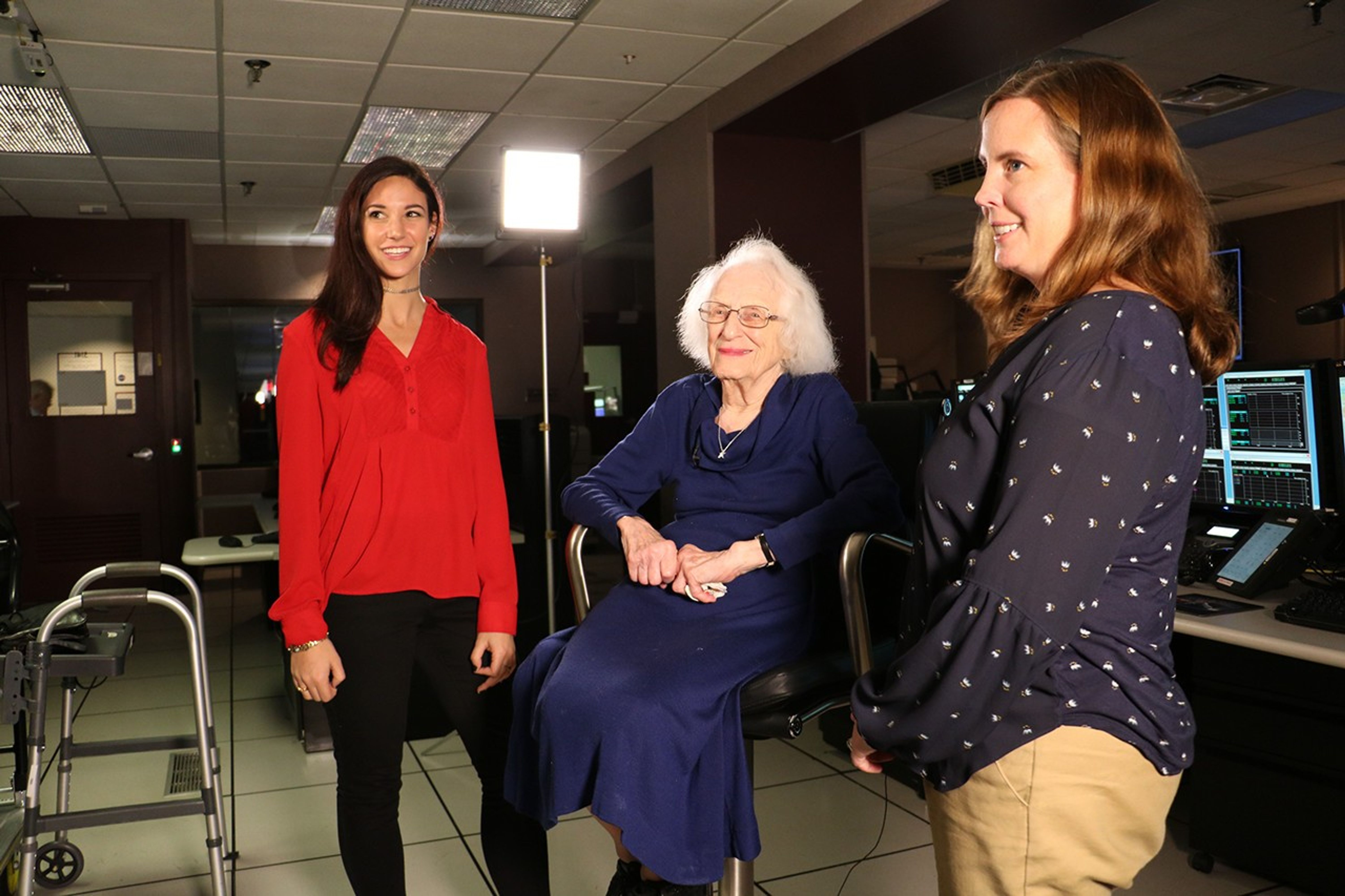 Dr. Roman sits in a chair for an interview, with Kisliuk and Van Arsdall on either side of her.