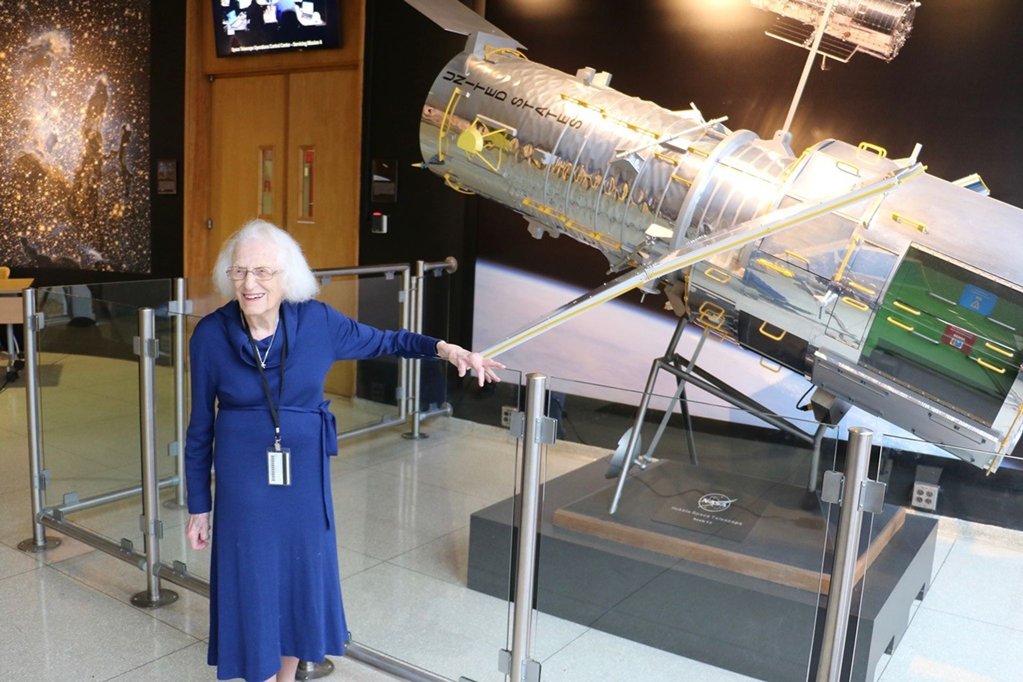 Dr. Roman poses in front of the Hubble model in the GSFC B3 Lobby.