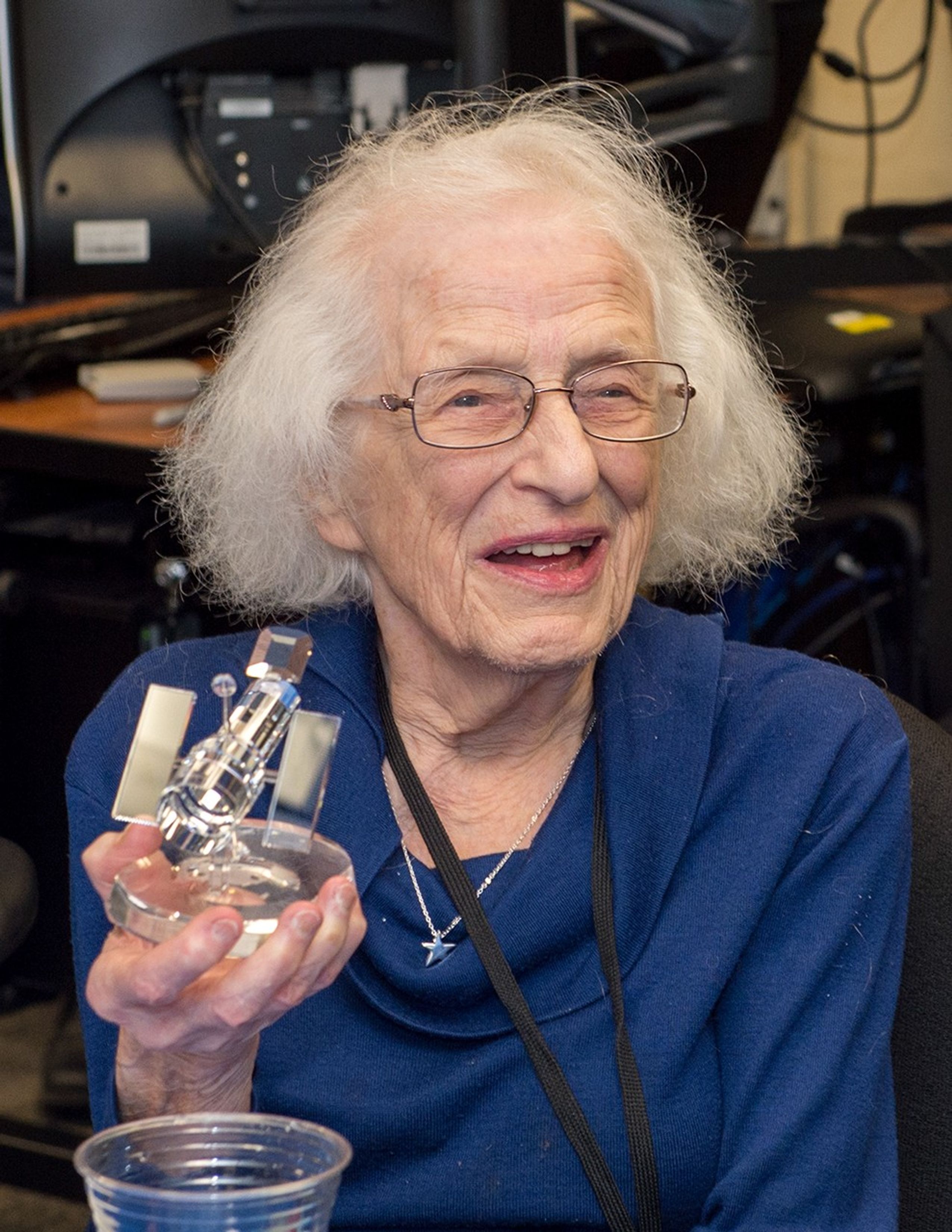 Nancy Grace Roman holds a glass model of the Hubble Space Telescope.