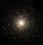 A bright white cluster of thousands of densely packed stars.