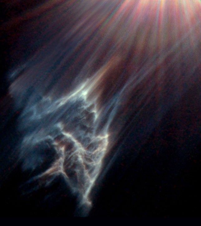 At lower left, ethereal bluish wisps form streaks and ridges.