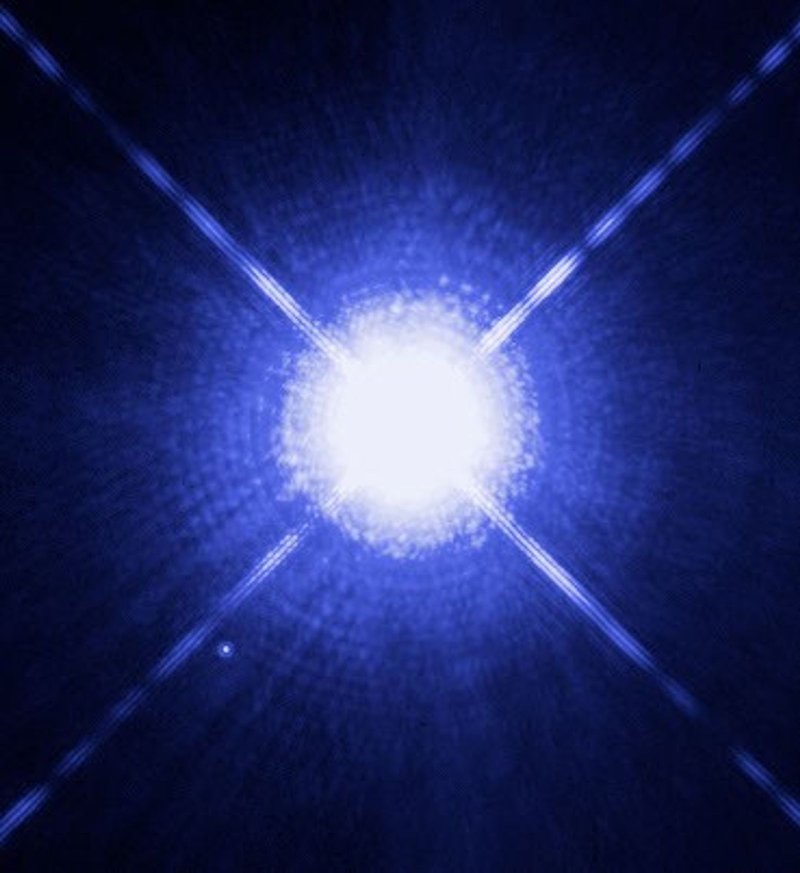 Hubble Space Telescope image showing the bright, overexposed star Sirius A at center with its faint white dwarf companion Sirius B visible as a tiny point of light nearby