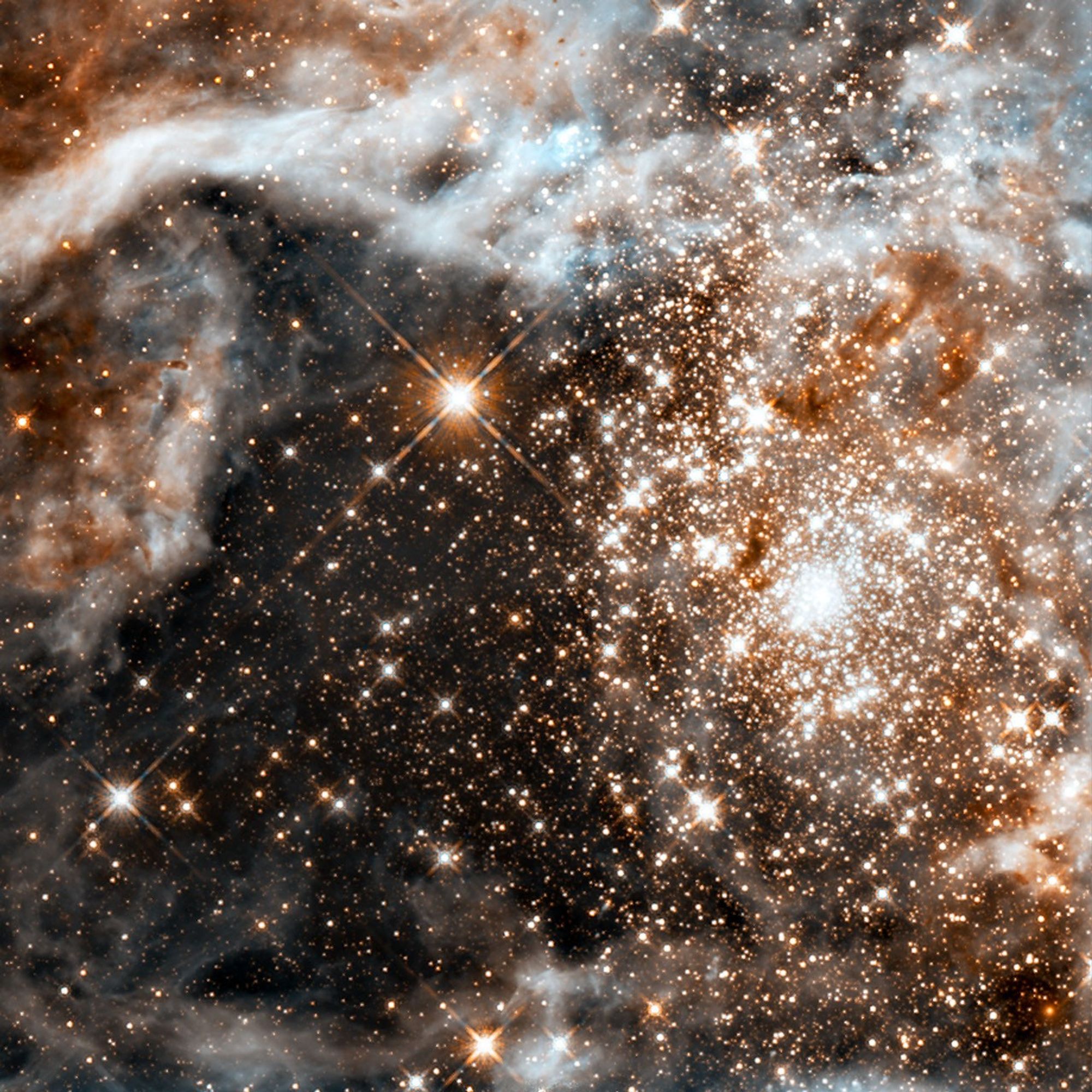 A dense cluster of bright yellow-white stars surrounded by fluffy brown and white material.