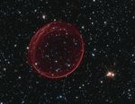 Supernova remnant resembling a bubble tinged with red.