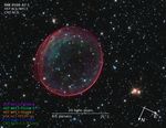 Colorful supernova remnant resembling a soap bubble on a dark background with compass arrows, scale bar, and color key for reference.