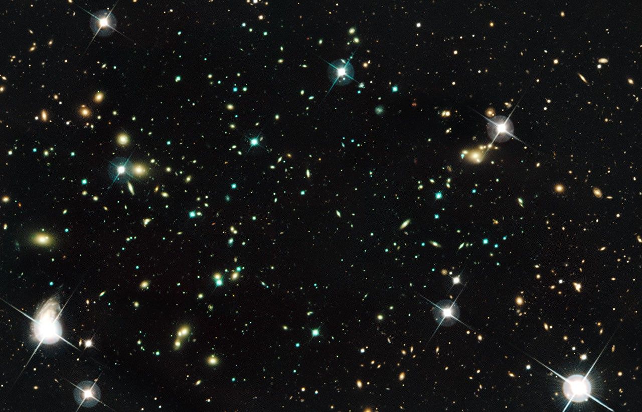 Hundreds of small galaxies against a dark background.