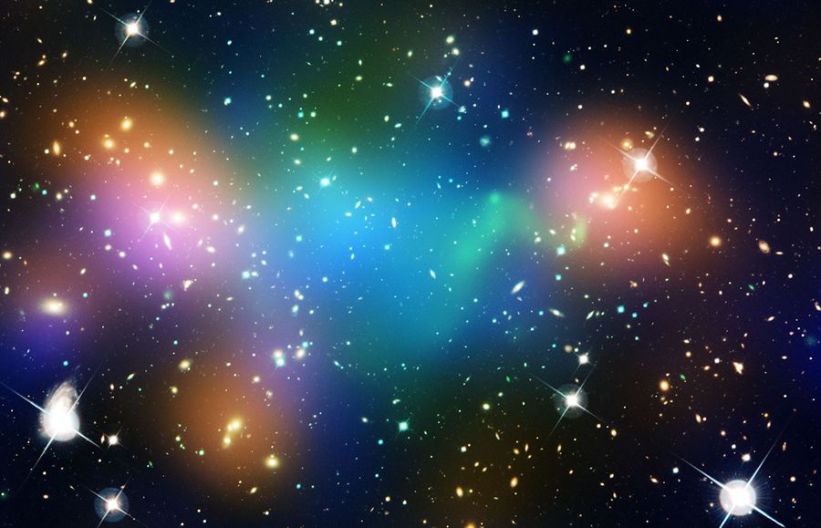 Hundreds of small galaxies with blue-green, orange, and purple-pink highlighted regions.