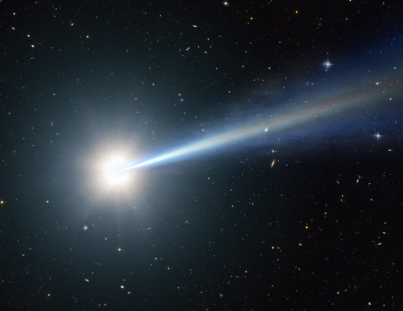 Small galaxies of varying shapes and colors are sprinkled across the black background of space. A white circle indicates a quasar, which appears much brighter than many of the galaxies in the foreground.