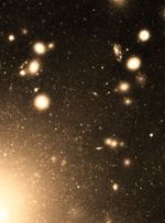 Light orange dots of different sizes are scattered on the black background of space.