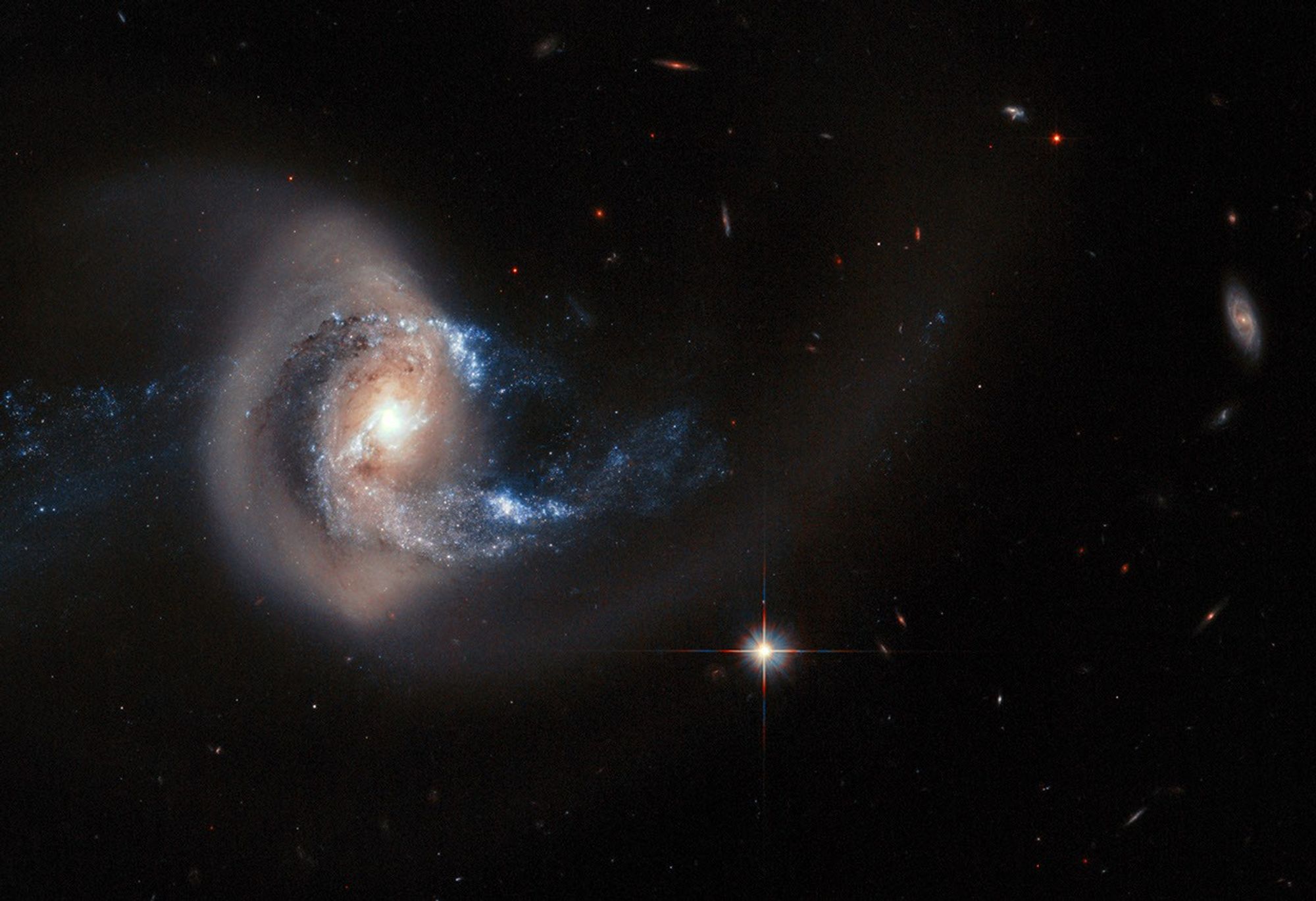 A galaxy in a backward S-shape is offset on the left side of the frame.