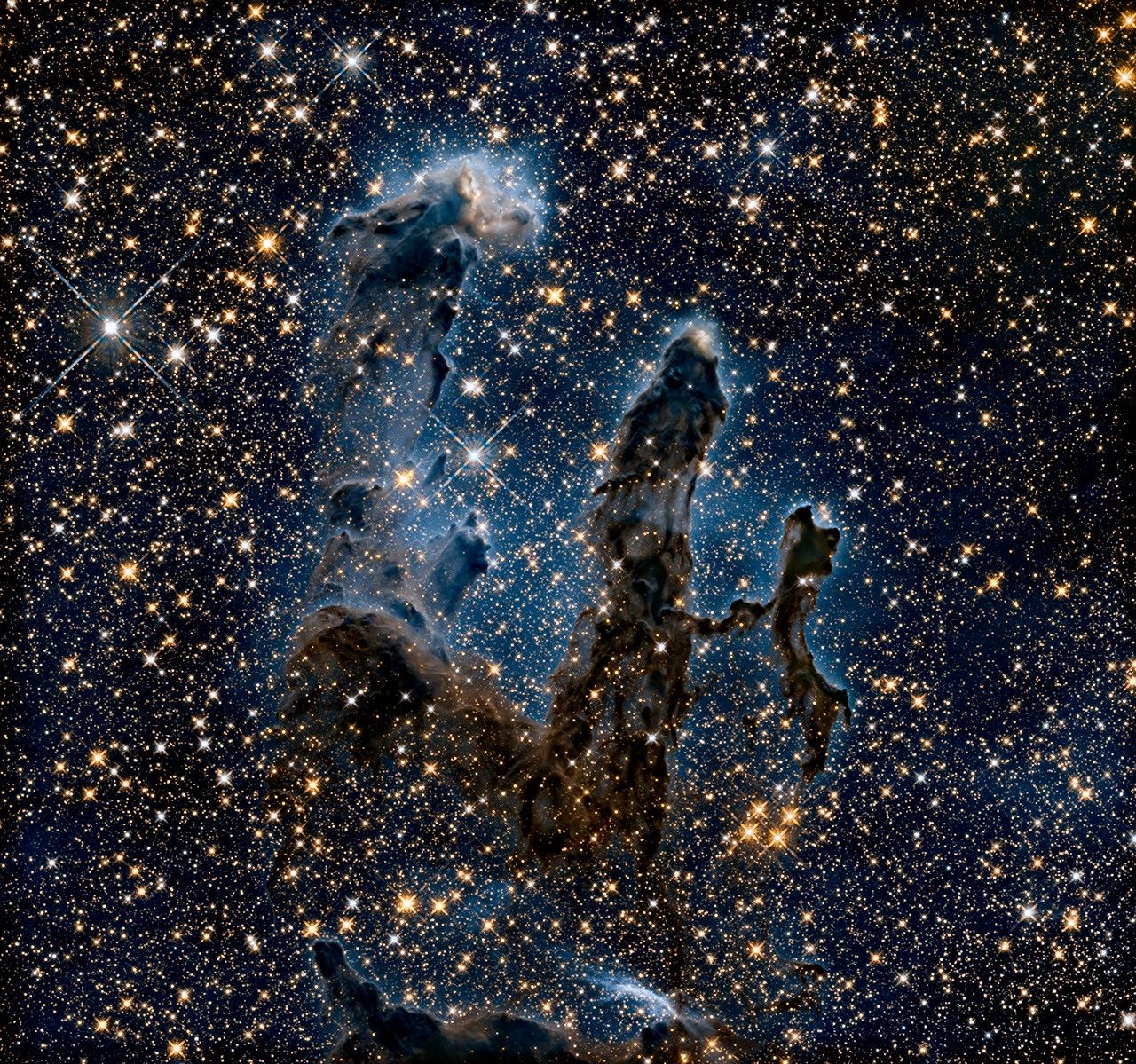 The Pillars of Creation. Wispy silhouettes of three columns against a dark, star-filled background.