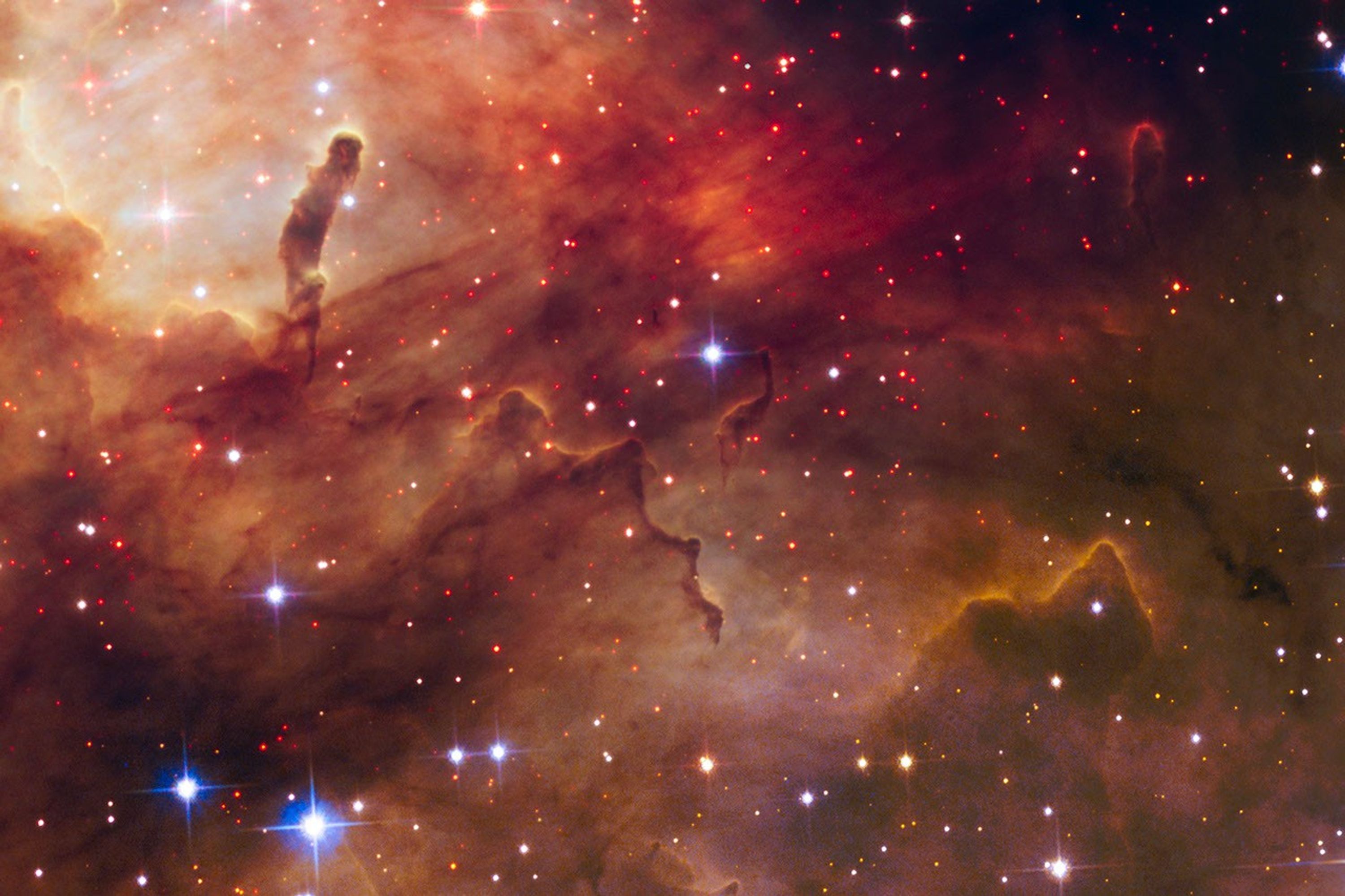 Horizontal scene shows a range of orange, brown, and bright red dust throughout.