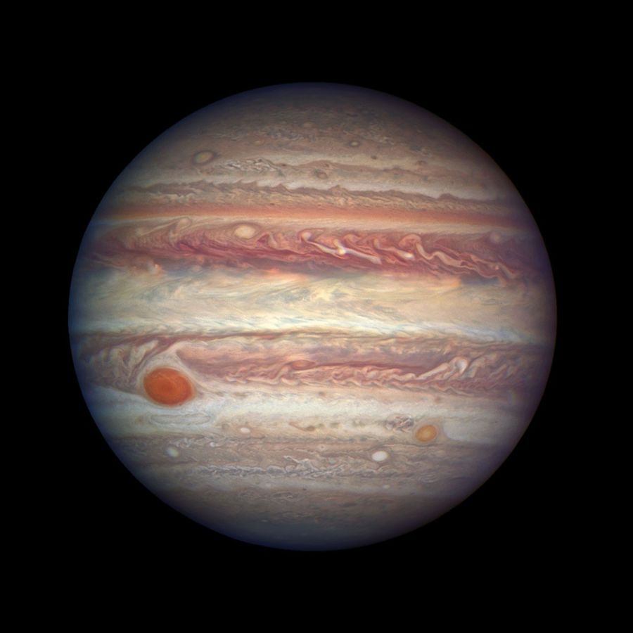 The planet Jupiter. A planet covered in horizontal bands of swirling clouds.