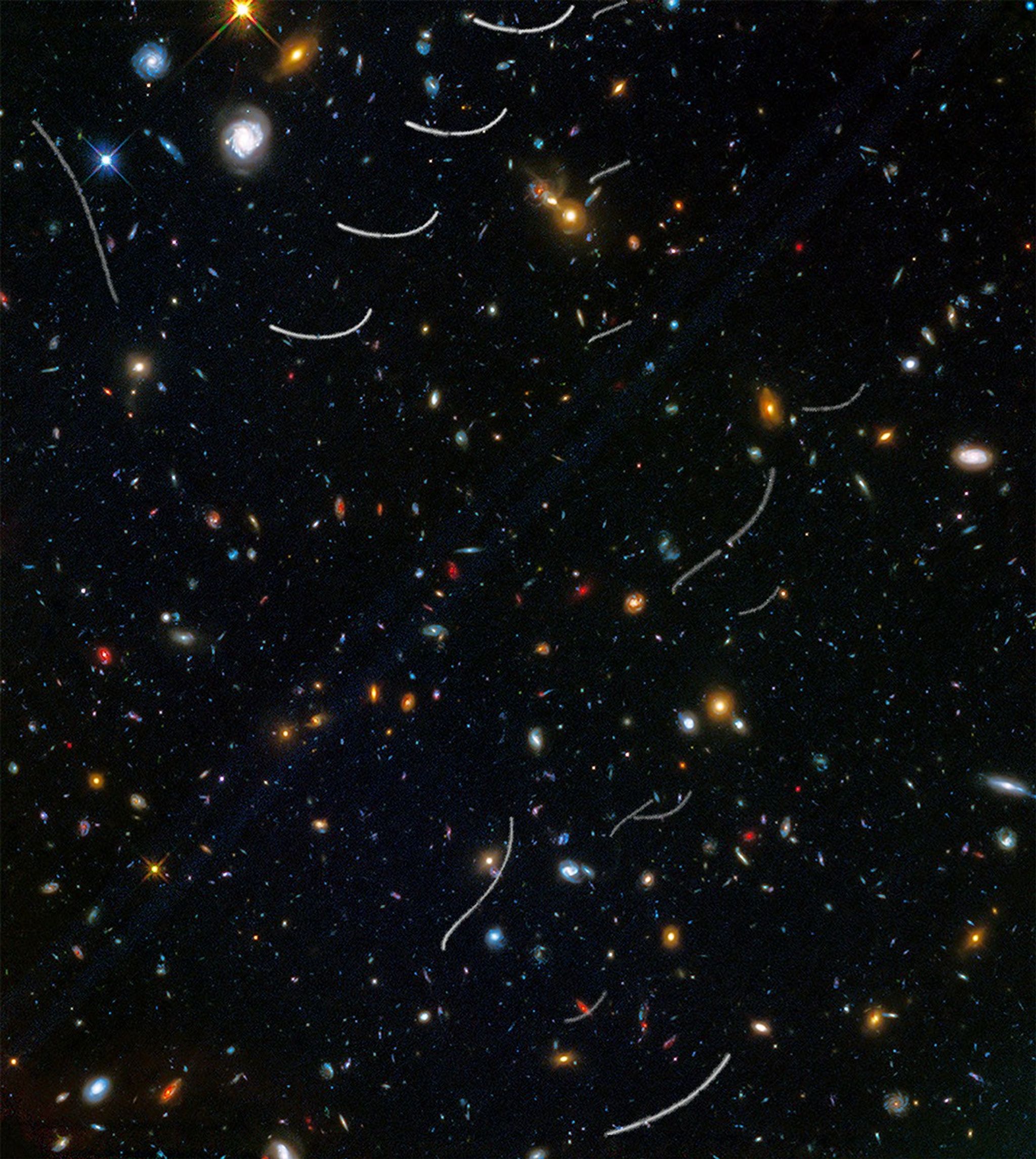 Hundreds of galaxies of various colors and sizes are scattered across the view, and about a dozen curved or wavy white streaks appear in random locations.