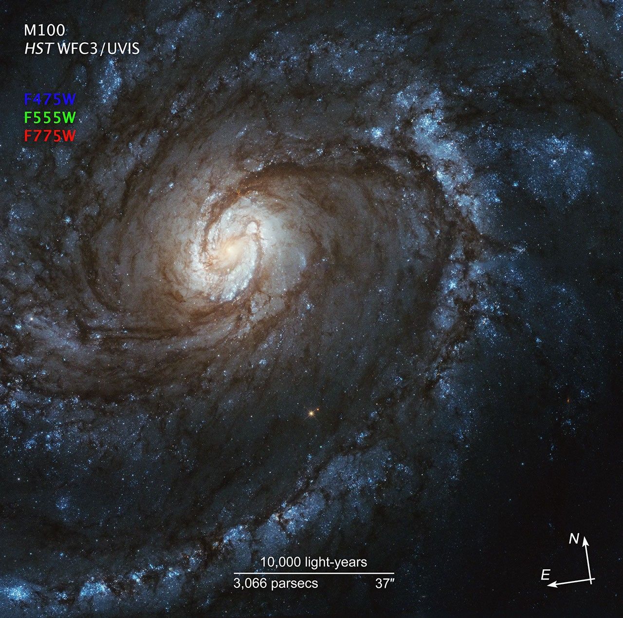 Image titled “M100, HST WFC3/UVIS” with compass arrows, scale bar, and color key.