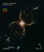 Colorful hourglass-shaped nebula with a bright white star and a glowing figure eight at its center on a dark background with compass arrows, scale bar, and color key for reference.