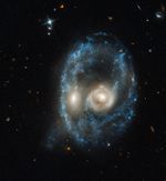 Galaxy merger that resembles the face of a mystical life form with glowing yellow eyes.