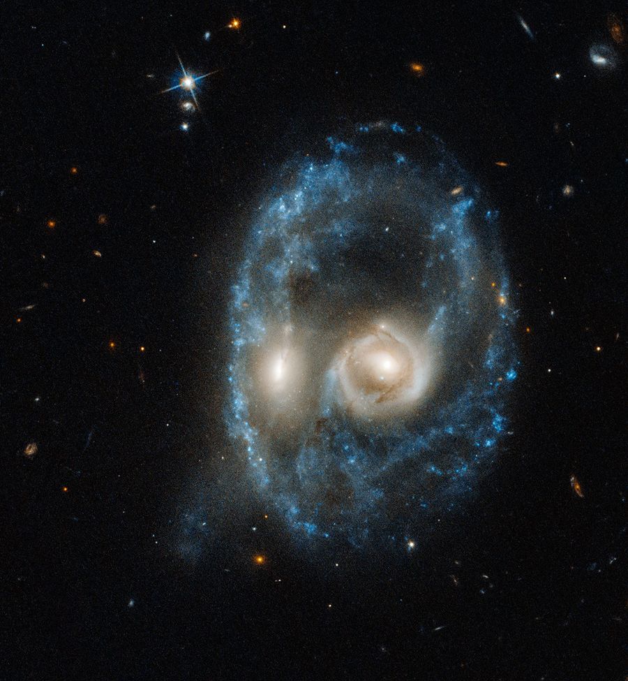 Galaxy merger that resembles the face of a mystical life form with glowing yellow eyes.