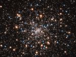Image of globular star cluster NGC 6397 containing blue stars, red giant stars, and a number of small white objects