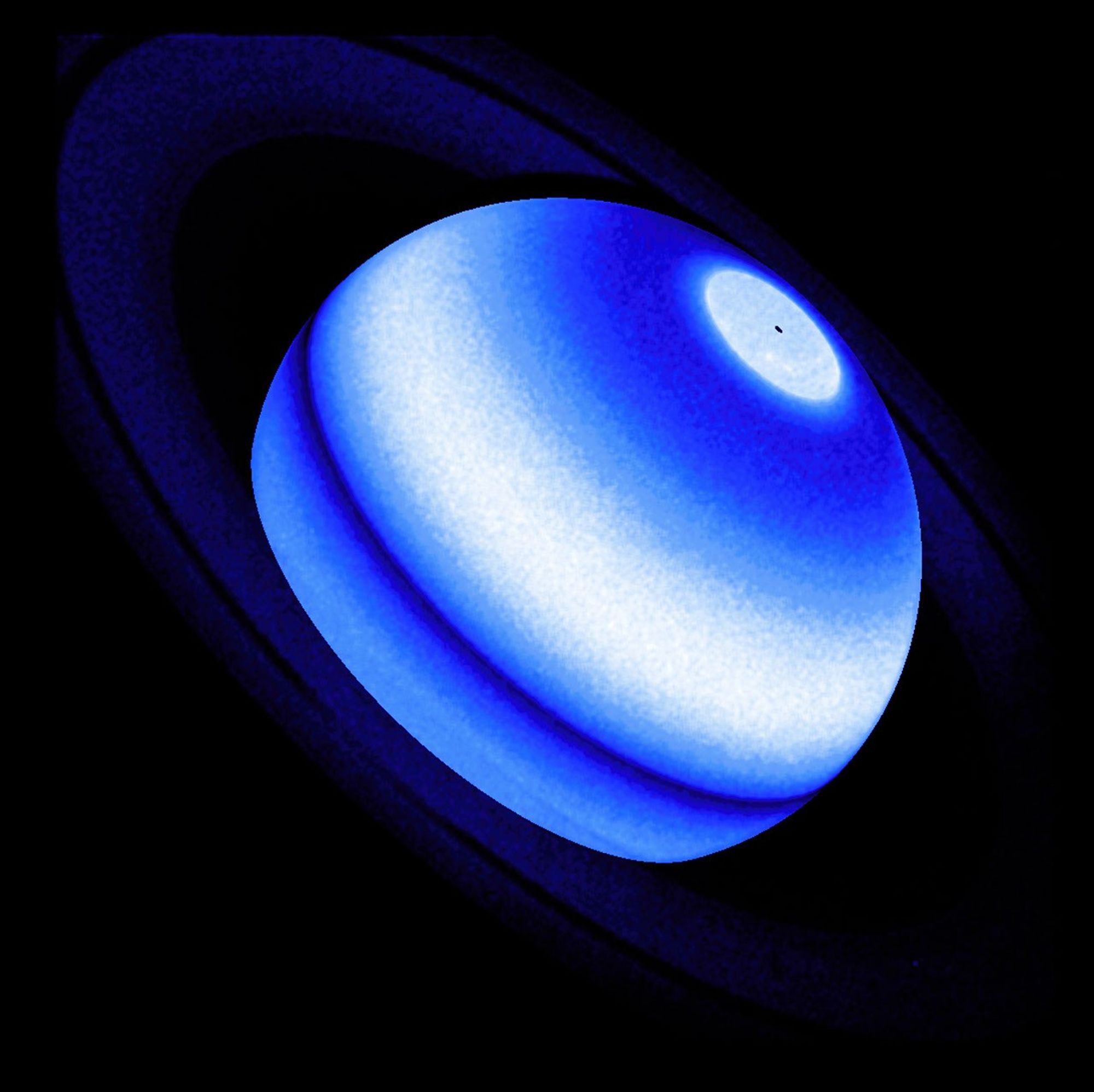 Against a black background, Saturn appears as a blue-and-white banded body encircled by a faint, deep blue system of rings.