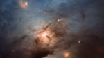 A vertical image with colors ranging from blue at the top to golden in the middle and red at the bottom. At the top, a bright blue star is illuminating surrounding clouds of gas, making the top third of the image appear blue. Below the bright star, a couple dozen fainter stars shine yellow. One of them has a fuzzy, golden arc to its left. At the center of the image, a brighter yellow star illuminates surrounding gas. It is partially obscured by dark streaks and clouds of dust, making it resemble the moon on a cloudy evening. The bottom of the image is noticeably darker than the rest, with the exception of a dramatic splash of red almost like a bug splat on a windshield. A handful of faint, red stars also appear there.