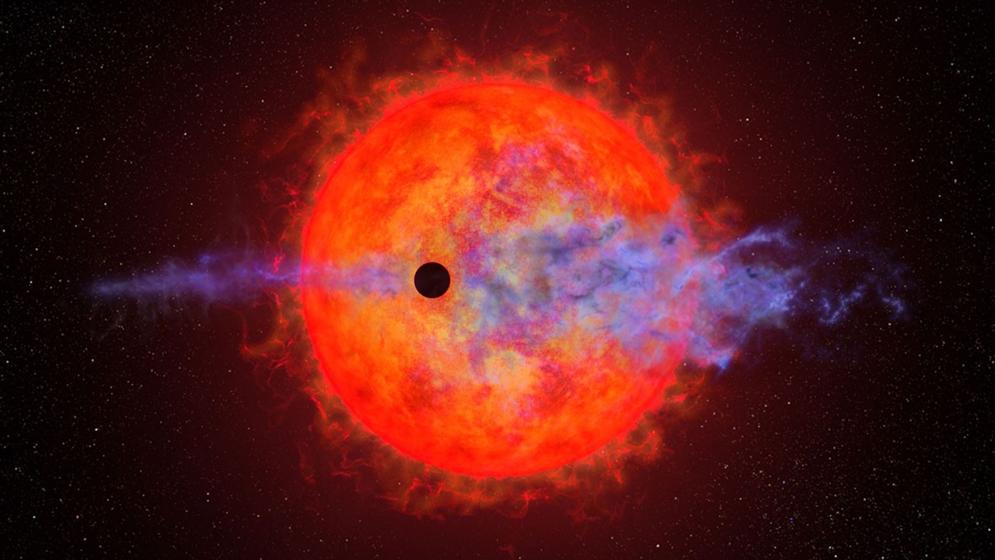 This illustration shows the ball of a red dwarf star. It is mottled with dark spots and finger-like filamentary outbursts. In front is a much smaller black circle representing the silhouette of a planet passing in front of the star. The red dwarf's furious activity is causing the planet's atmosphere to escape into space. This appears as wispy blue filaments along the planet's straight horizontal orbital path. The star is colored a rich red because it is cooler than our Sun.