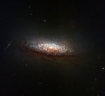 At center is a new Hubble telescope image of the nearby galaxy NGC 1546. The galaxy's orientation gives us a good view of dust lanes from slightly above and backlit by the galaxy's core.