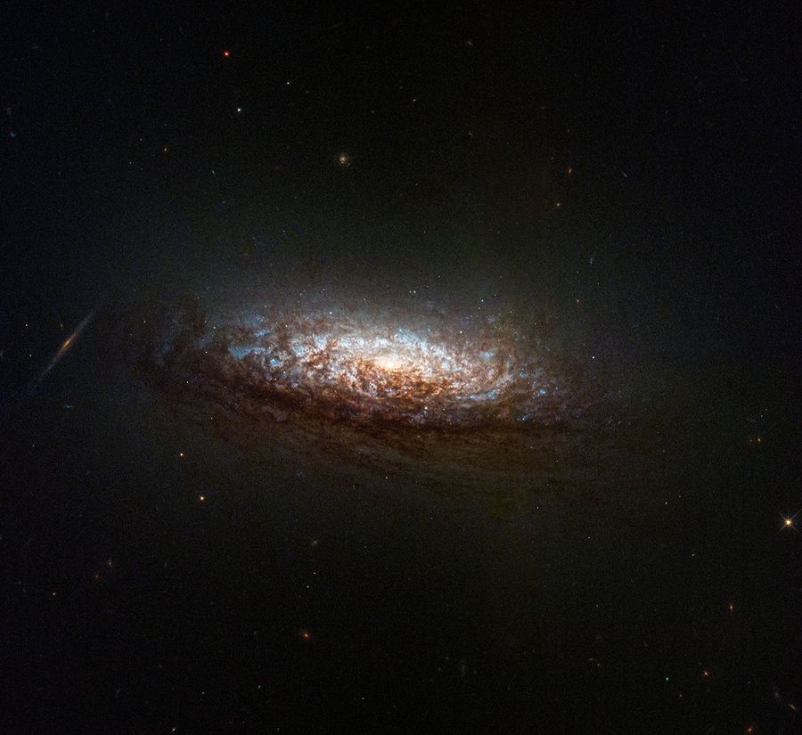 At center is a new Hubble telescope image of the nearby galaxy NGC 1546. The galaxy's orientation gives us a good view of dust lanes from slightly above and backlit by the galaxy's core.