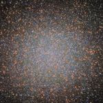 An image of the globular cluster Omega Centauri, a collection of myriad stars colored red, white, and blue on the black background of space.