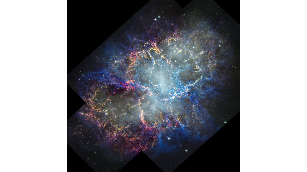 Colorful nebula in space with a white haze throughout that is more concentrated in the center with a rippling effect. Colorful gas filaments appear to splash outward from the nebula center, colored yellow, magenta, and blue. Small white stars dot the background.