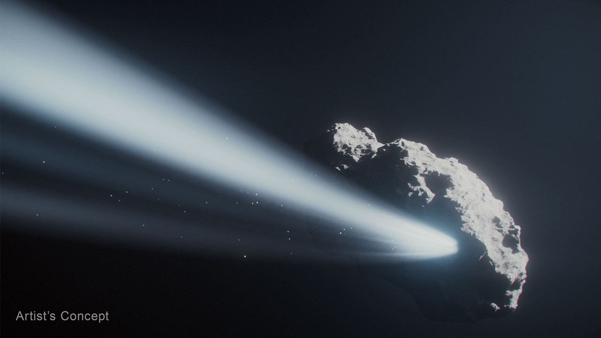 Illustration, close up of rocky, potato-shaped body of a comet with detailed, cratered surface at the bottom right. A glowing ray emanates from the rocky surface like sunlight through clouds. It extends from the comet’s surface across the image to the left. This represents water ice being vaporized by the heat of the Sun. There are small bright dots within the ray, representing fragments of the comet. The words Artist's Concept appear at the bottom left.
