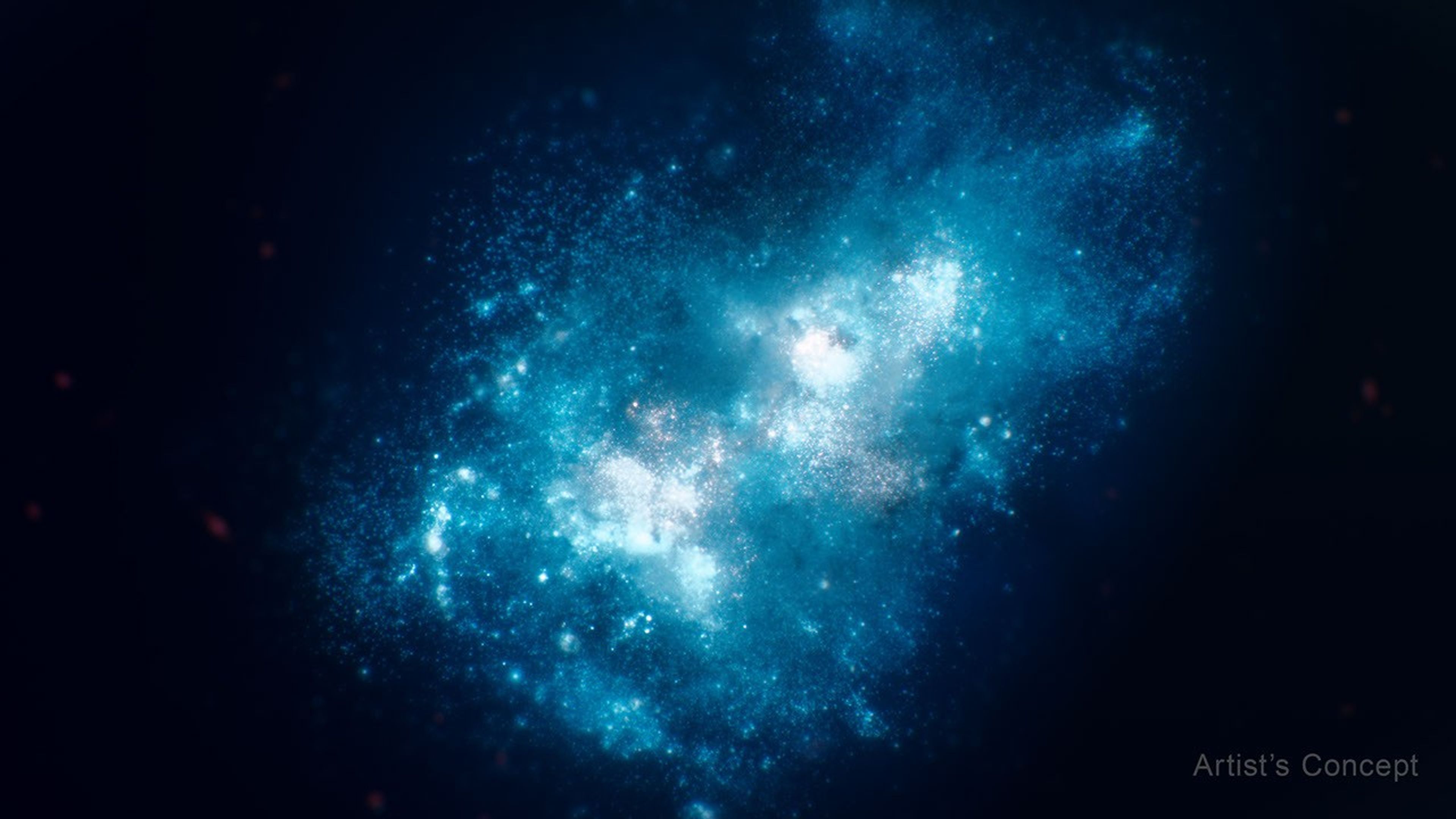 Illustration shows a closeup of a galaxy forming in the early universe. It appears chaotic and takes up most of the frame, from bottom left to top right. At the center are several bright white and blue blobs, which are areas of concentrated star formation. The blue becomes slightly darker in areas around this, taking up more than half of the galaxy’s overall size. There are smaller regions of bright blue star formation throughout this section. The galaxy’s edges, also irregularly shaped, are a medium blue, and smaller areas of star formation are apparent. The black background of space surrounds the galaxy.
