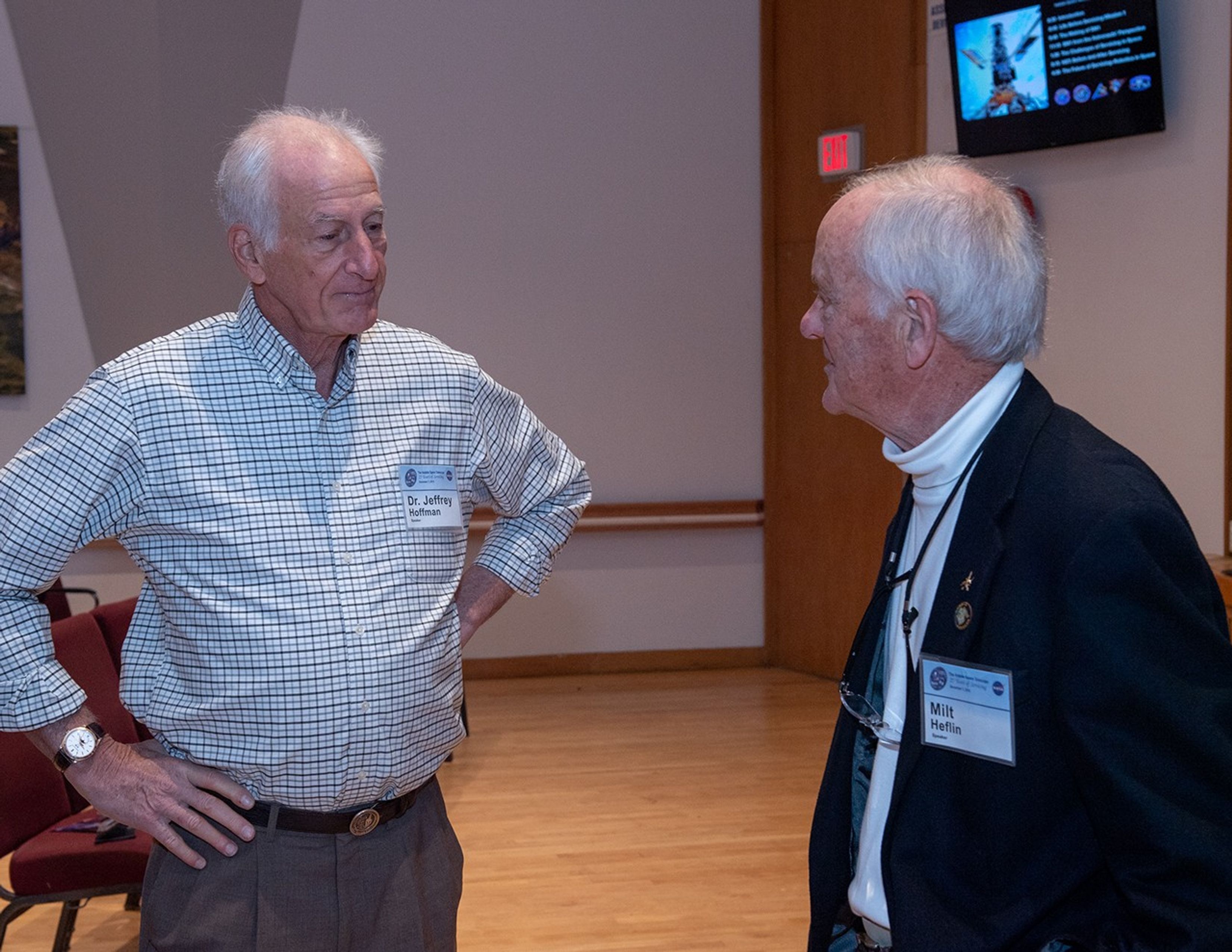 Two men, Jeffrey Hoffman (left) and Milt Heflin (right), converse with each other.