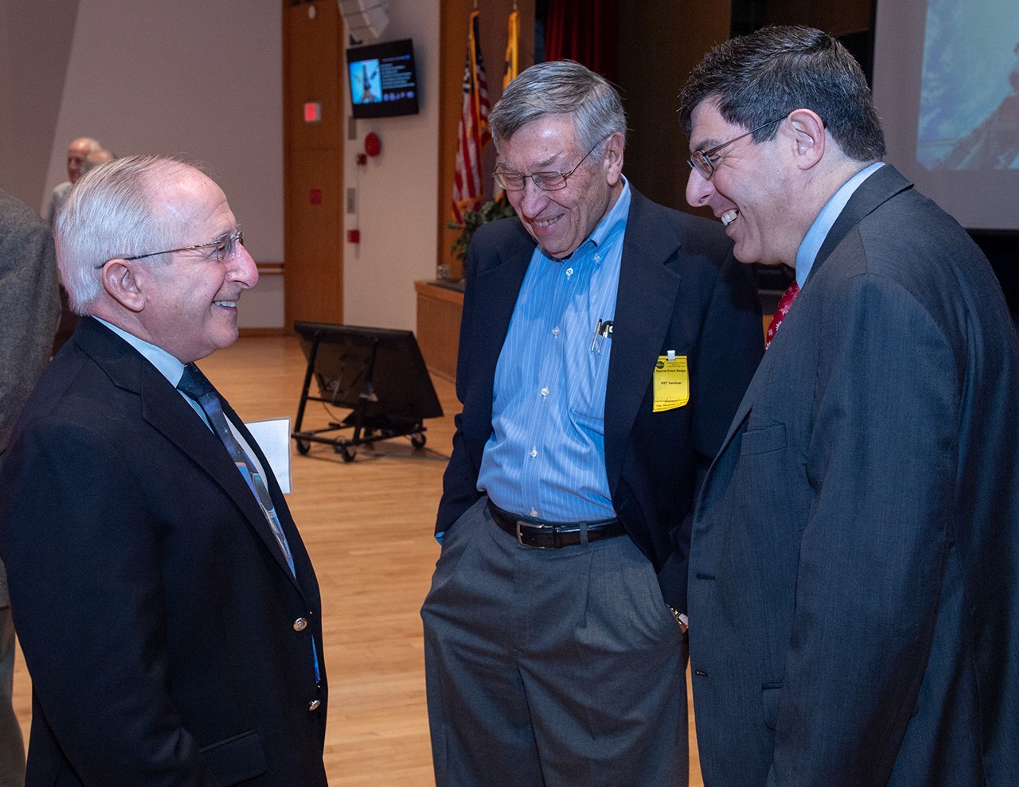 Three men stand talking: Joseph Rothenberg (left), Vernon Weyers (center) and Christopher Scolese (right).