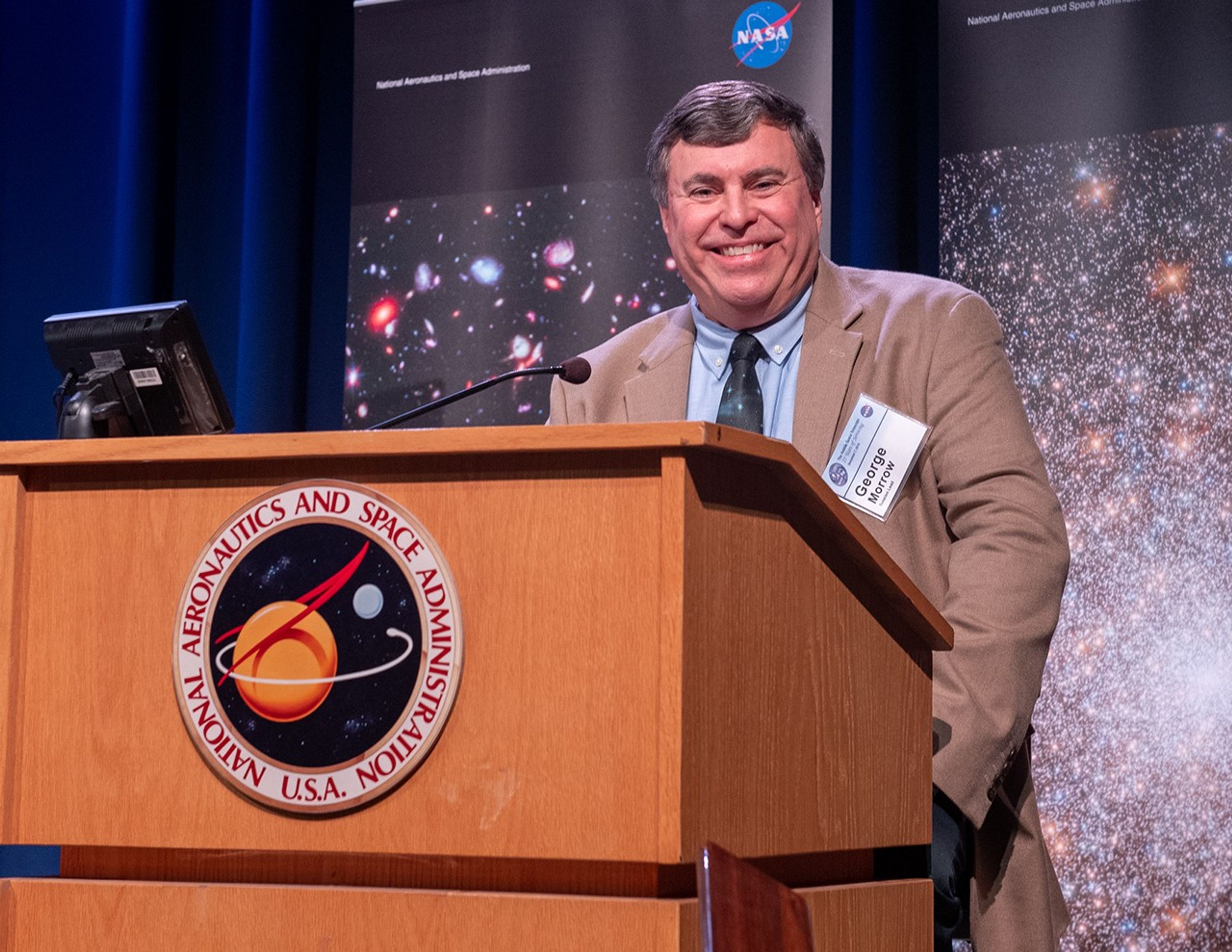 George Morrow stands at the NASA podium, smiling for the camera.