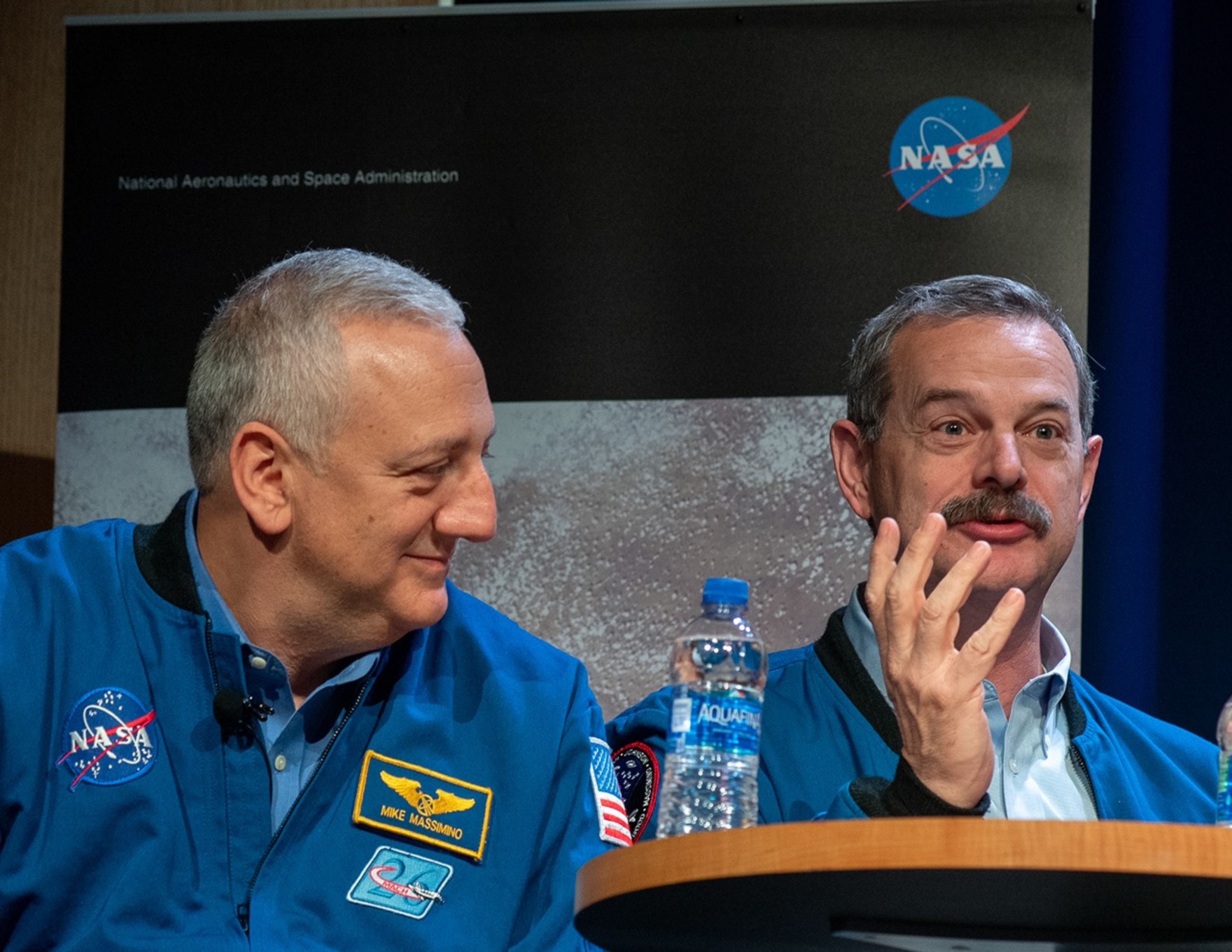Mike Massimino (left) looks at Scott Altman (right) as he addresses the audience.