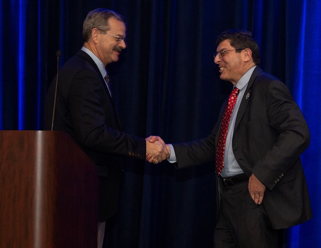 Scott Altman (left) and Christopher Scolese (right) shake hands at the podium.