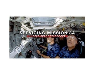 Two astronauts inside the space shuttle. Title: "Servicing Mission 3A" in white, "Hubble Space Telescope" written below the main title in white and highlighted in red.