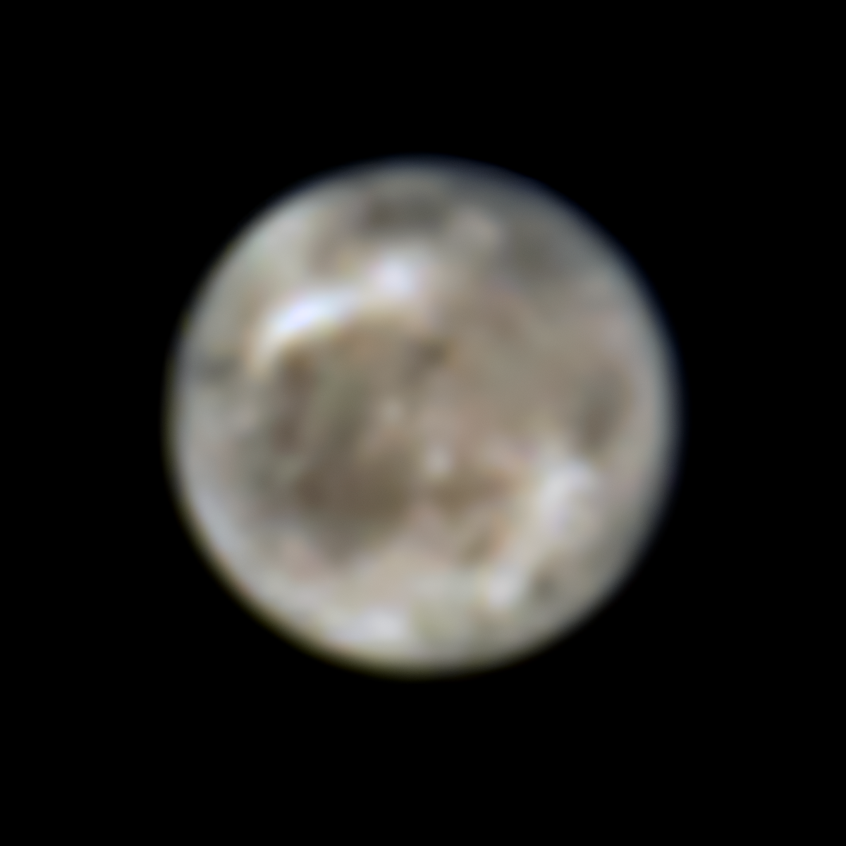 A hazy, out-of-focus sphere of a moon, gray-brown with large white streaks and smaller off-white patches.