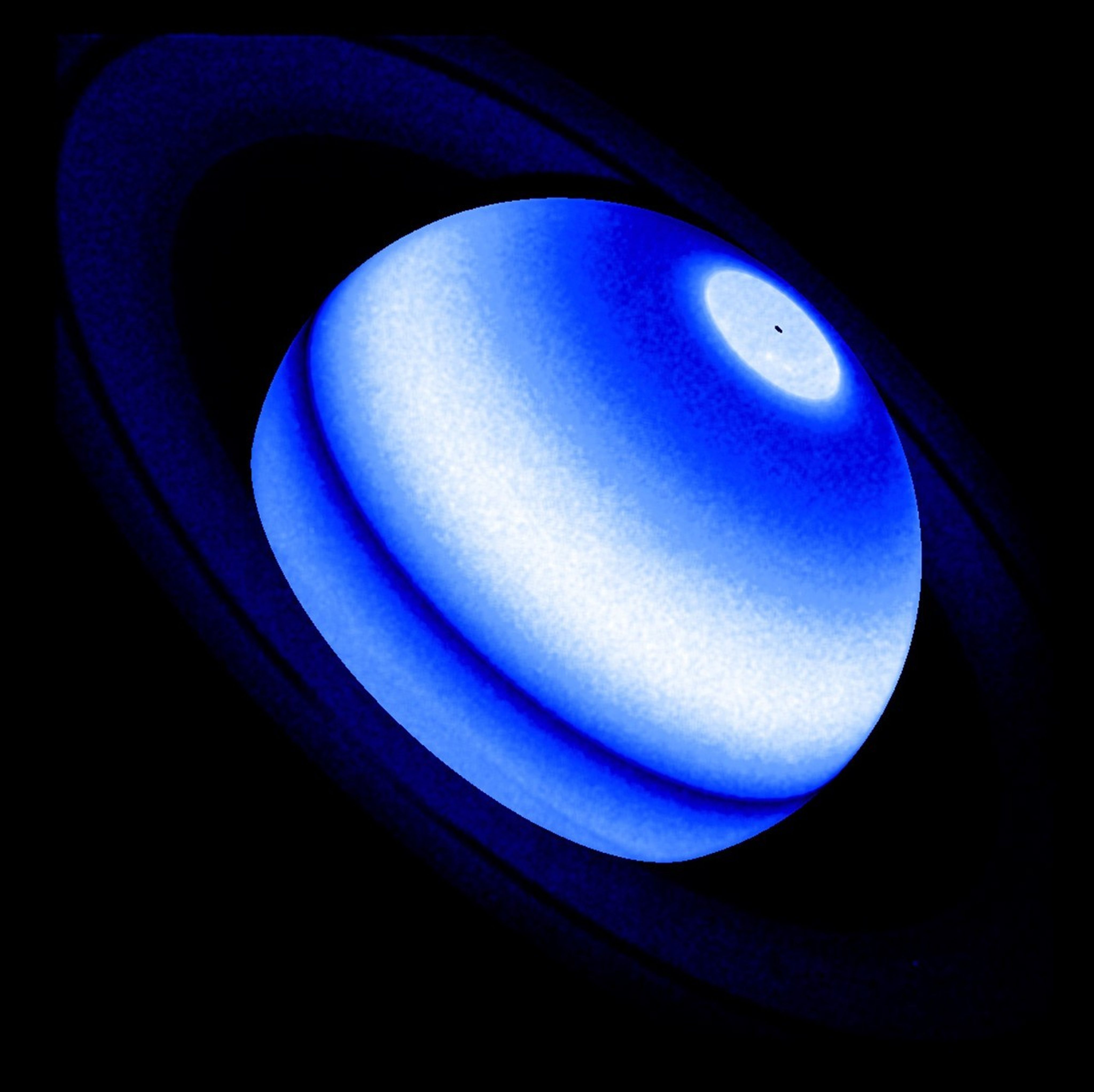 An image of Saturn. Its rings stretch across the image from the upper-left to the lower-right. The rings appear dark blue, nearly black. The planet is a series of dark blue, blue, light blue, and white bands.