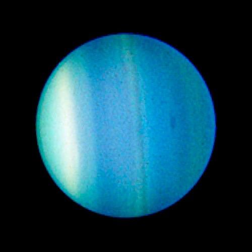 The clouds of Uranus form bands that run of the top of the planet (relative to the picture) to the bottom, due to Uranus lying on its side. These bands are shades of light blue, light green, and white. A small, slightly-darker blue patch is visible on the right.