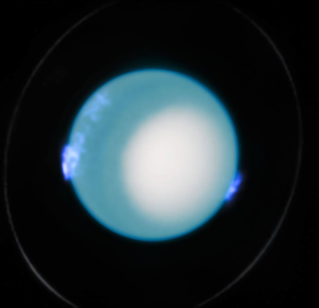 This Hubble image shows Uranus and dynamic aurora activity on 10 October 2022. The planet is dominated by a blue hue and a large white region in the lower left. A faint ring is also visible around the planet. Fuzzy blue/purple regions hovering over the planet on the left and ride indicate the presence of aurorae.