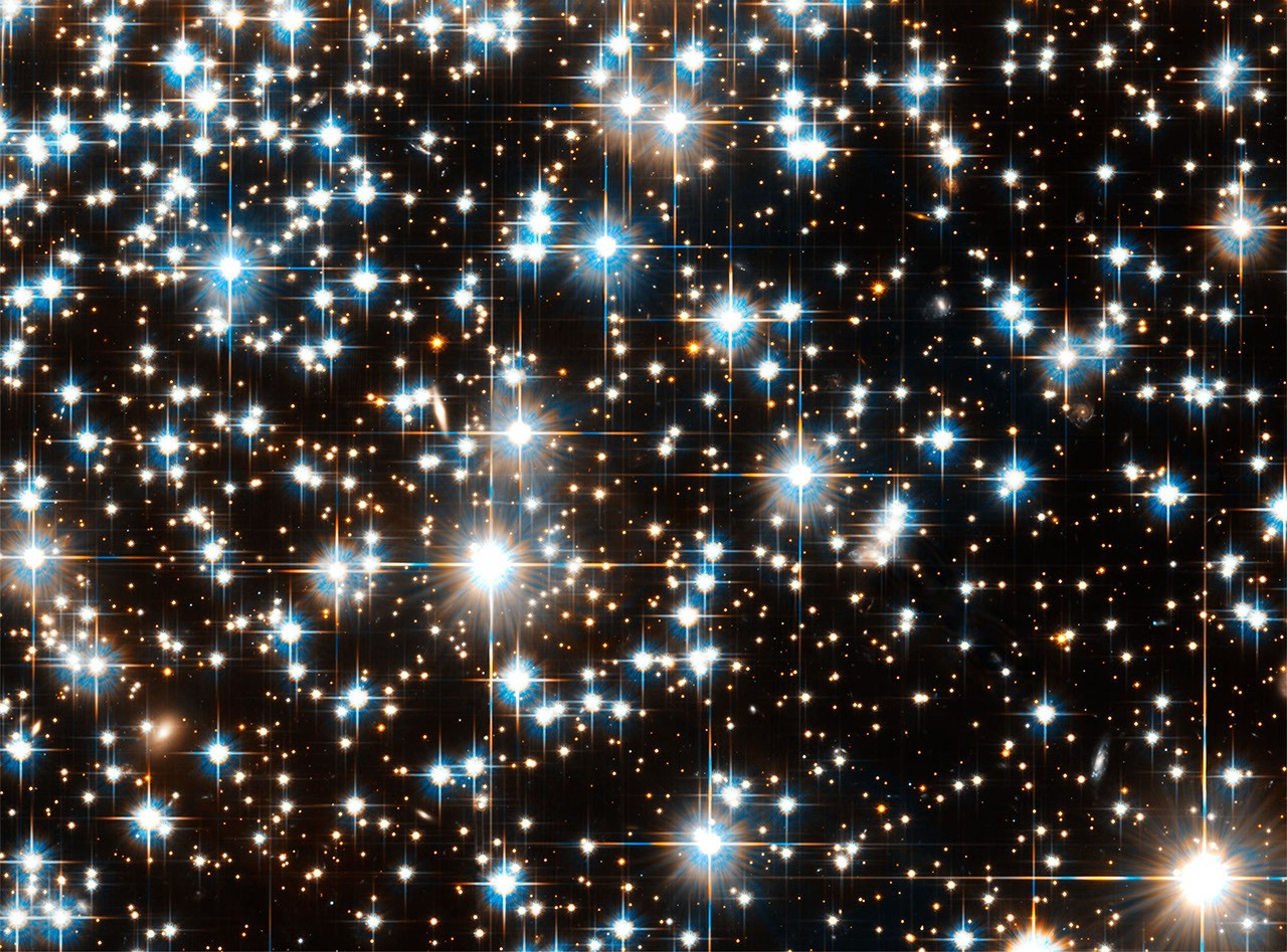 Dozens of bluish-white (sometimes with a reddish outer hue) shining brightly, with hundreds more stars in the background.